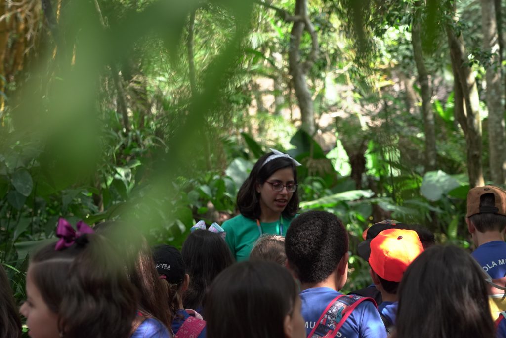 Educadora ambiental realizando uma trilha com crianças