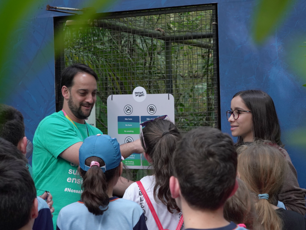 Educador Ambiental orientando visitantes na entrada de um viveiro no Parque das Aves