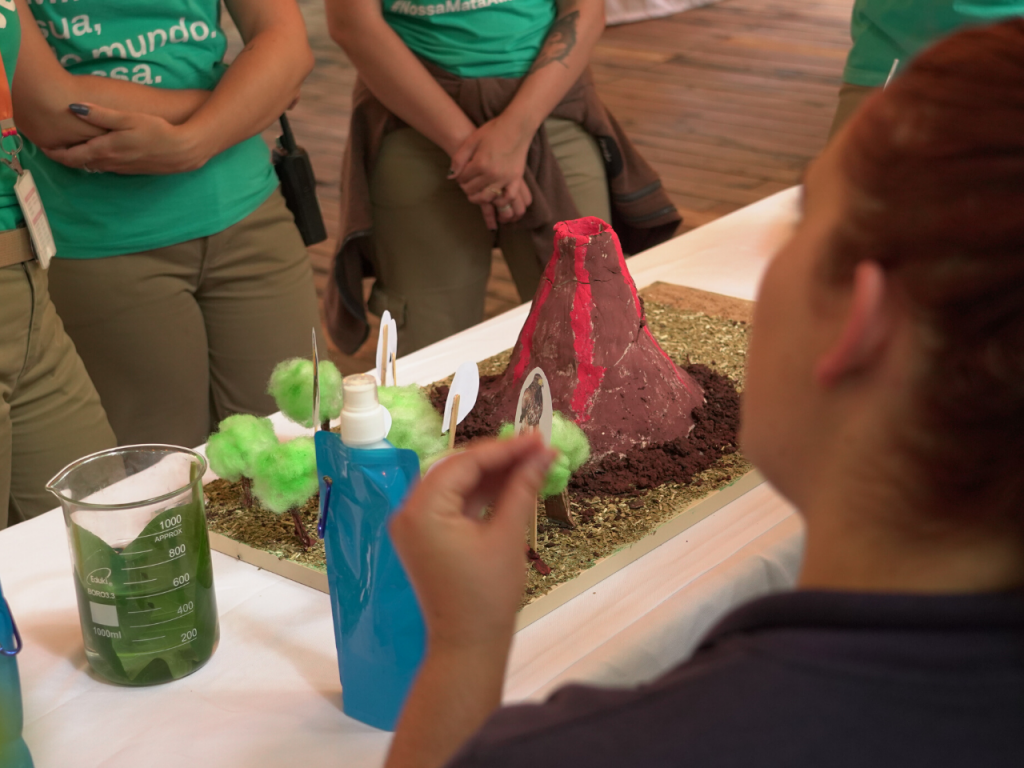 Estudante apresentando uma maquete de vulcão