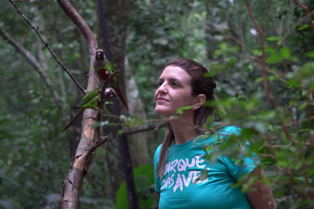 Mulher observando a natureza, usando camiseta do Parque das Aves