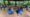 Grupo de crianças vestindo coletes "Guardiões da Mata Atlântica" sentadas no chão de um espaço coberto no Parque das Aves, ouvindo atentamente um educador. 
