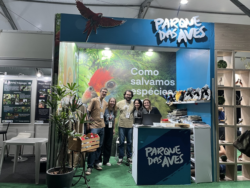 Estande do Parque das Aves no Avistar 2024 com equipe reunida à frente da estrutura.