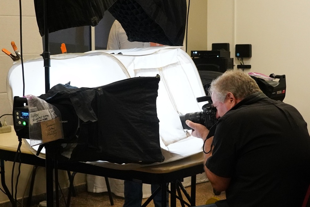 Fotógrafo Joel Sartore em ação capturando imagens de animais pequenos dentro de estúdio portátil do Photo Ark do National Geografic.