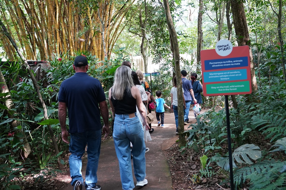 Visitantes caminham pelas trilhas do Parque das Aves em meio à vegetação da Mata Atlântica.