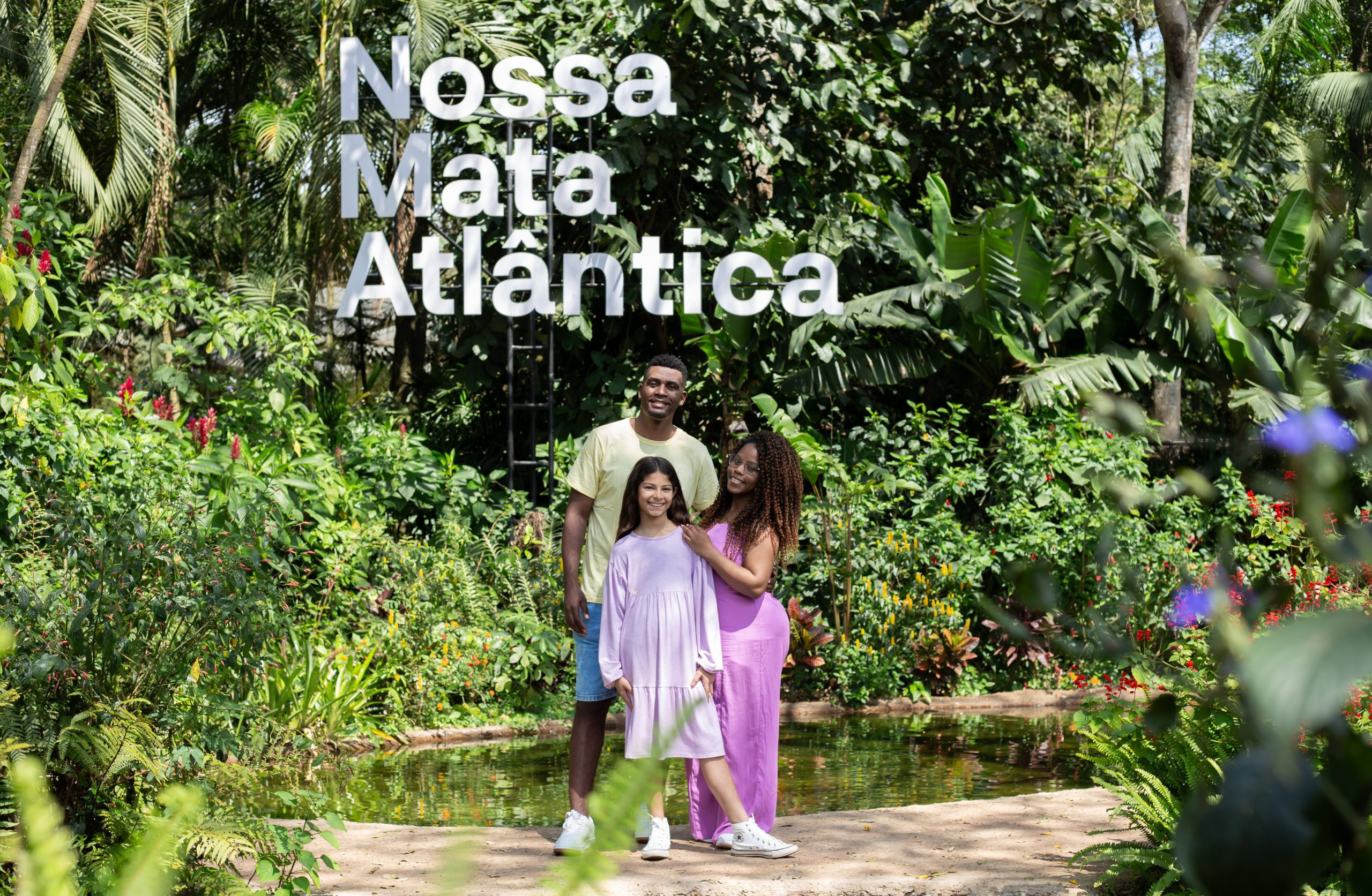 Família posa em frente ao letreiro "Nossa Mata Atlântica" durante visita ao Parque das Aves, em Foz do Iguaçu.